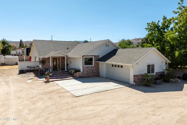 a view of house with yard and sitting area