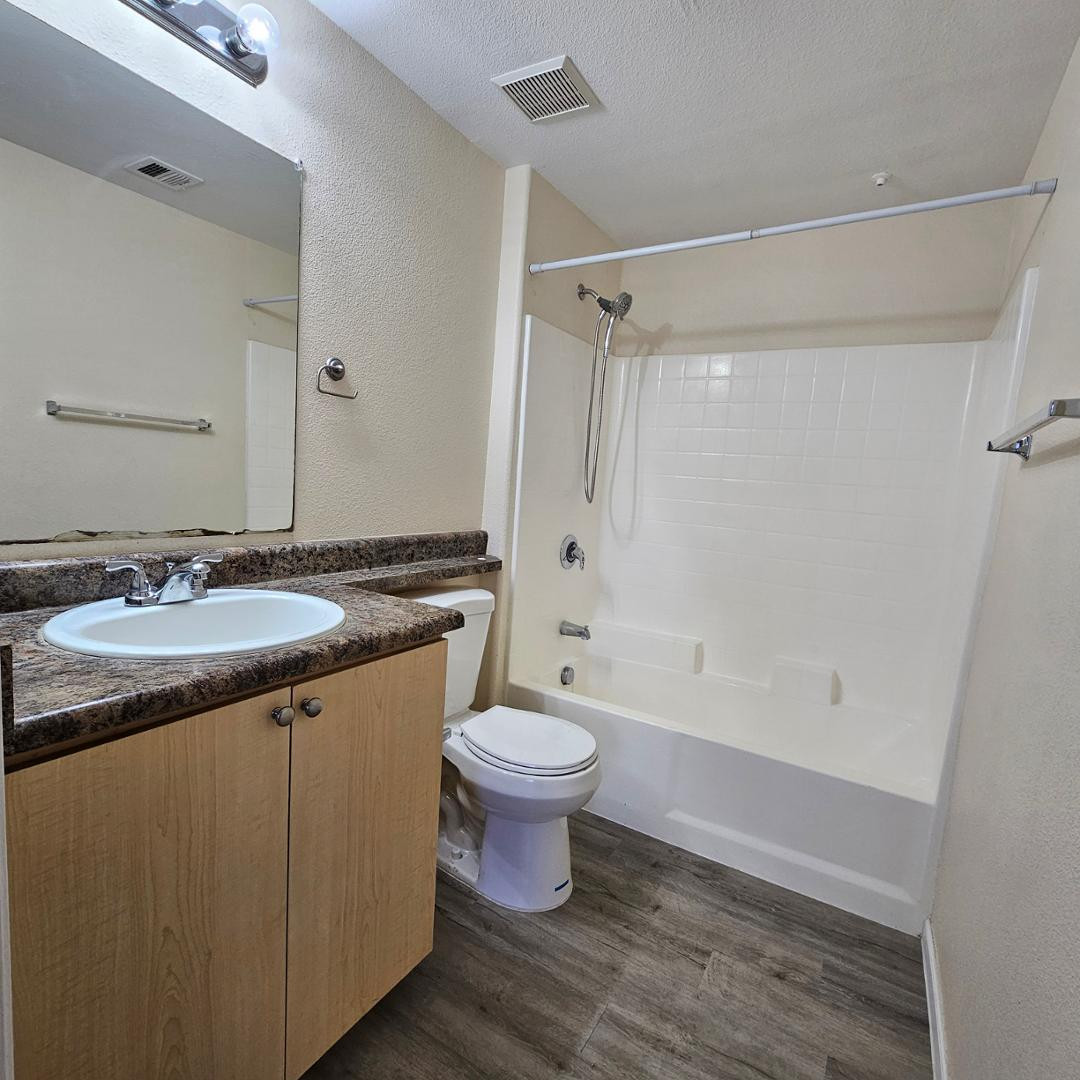 18416 North Cave Creek Road, Unit 2057 Phoenix, AZ 85032 - Photo 7 of 11 a bathroom with a granite countertop toilet a sink and a shower