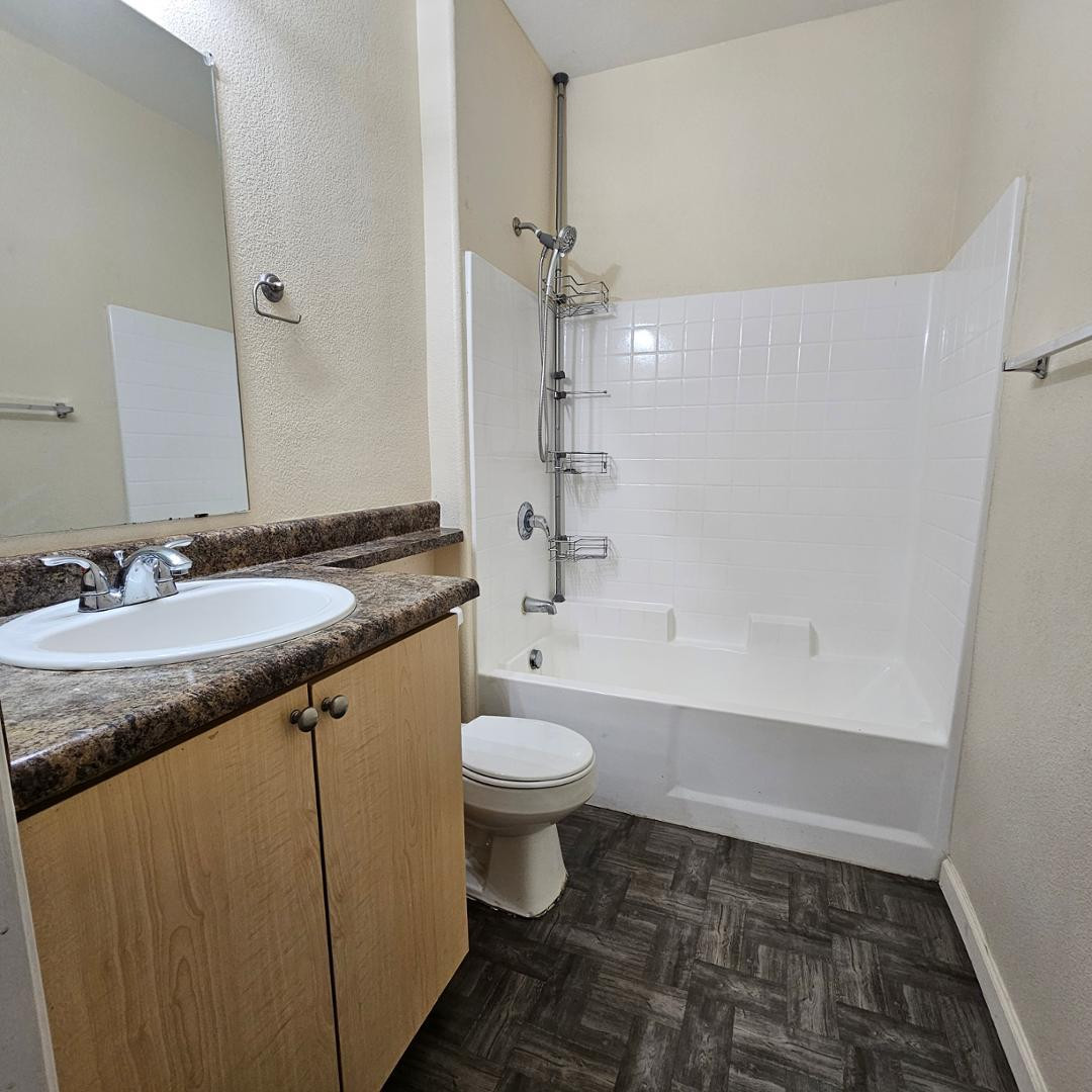 18416 North Cave Creek Road, Unit 2057 Phoenix, AZ 85032 - Photo 10 of 11 a bathroom with a granite countertop sink a toilet a mirror and bathtub