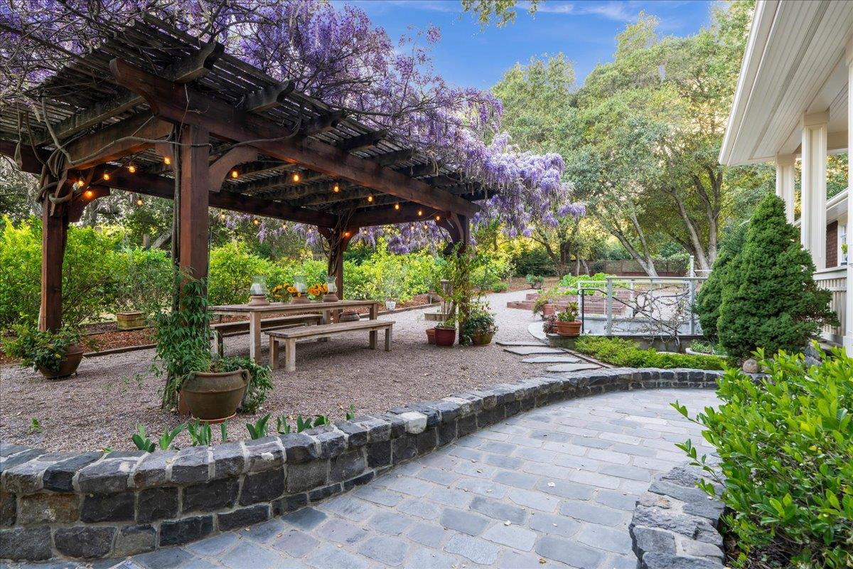 3510 Alpine Road Portola Valley, CA 94028 - Photo 63 of 77 a view of a patio with table and chairs potted plants and large tree