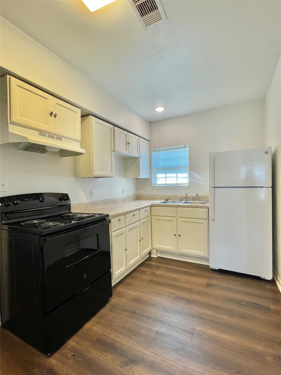 1755 West 6th Street Freeport, TX 77541 - Photo 17 of 19 a kitchen with a stove white cabinets and wooden floor
