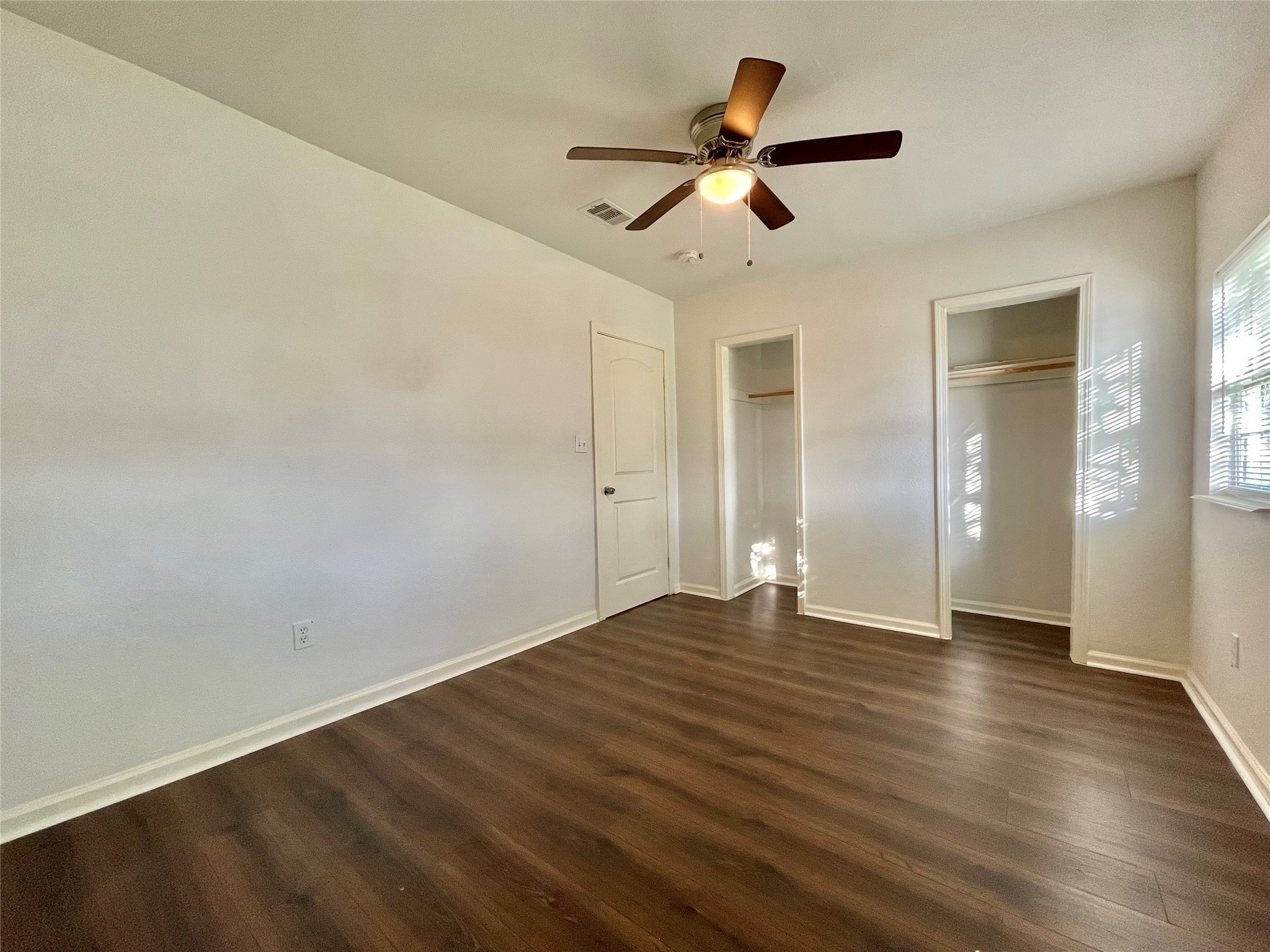 1755 West 6th Street Freeport, TX 77541 - Photo 7 of 19 an empty room with wooden floor ceiling fan and windows