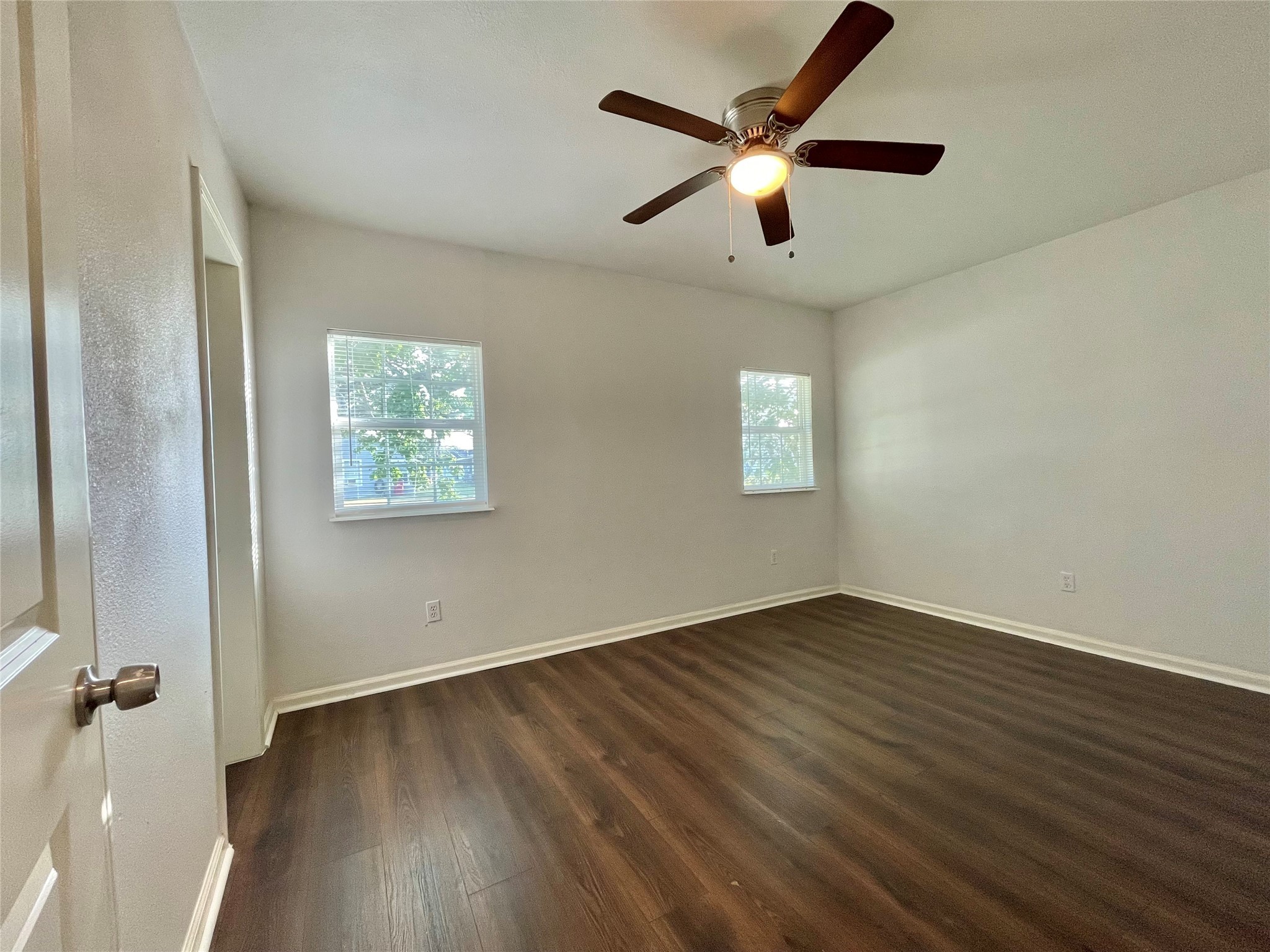 1755 West 6th Street Freeport, TX 77541 - Photo 10 of 19 an empty room with wooden floor ceiling fan and windows