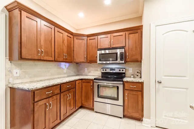a kitchen with stainless steel appliances granite countertop a stove microwave and sink