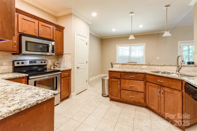 a kitchen with stainless steel appliances granite countertop a stove microwave and sink