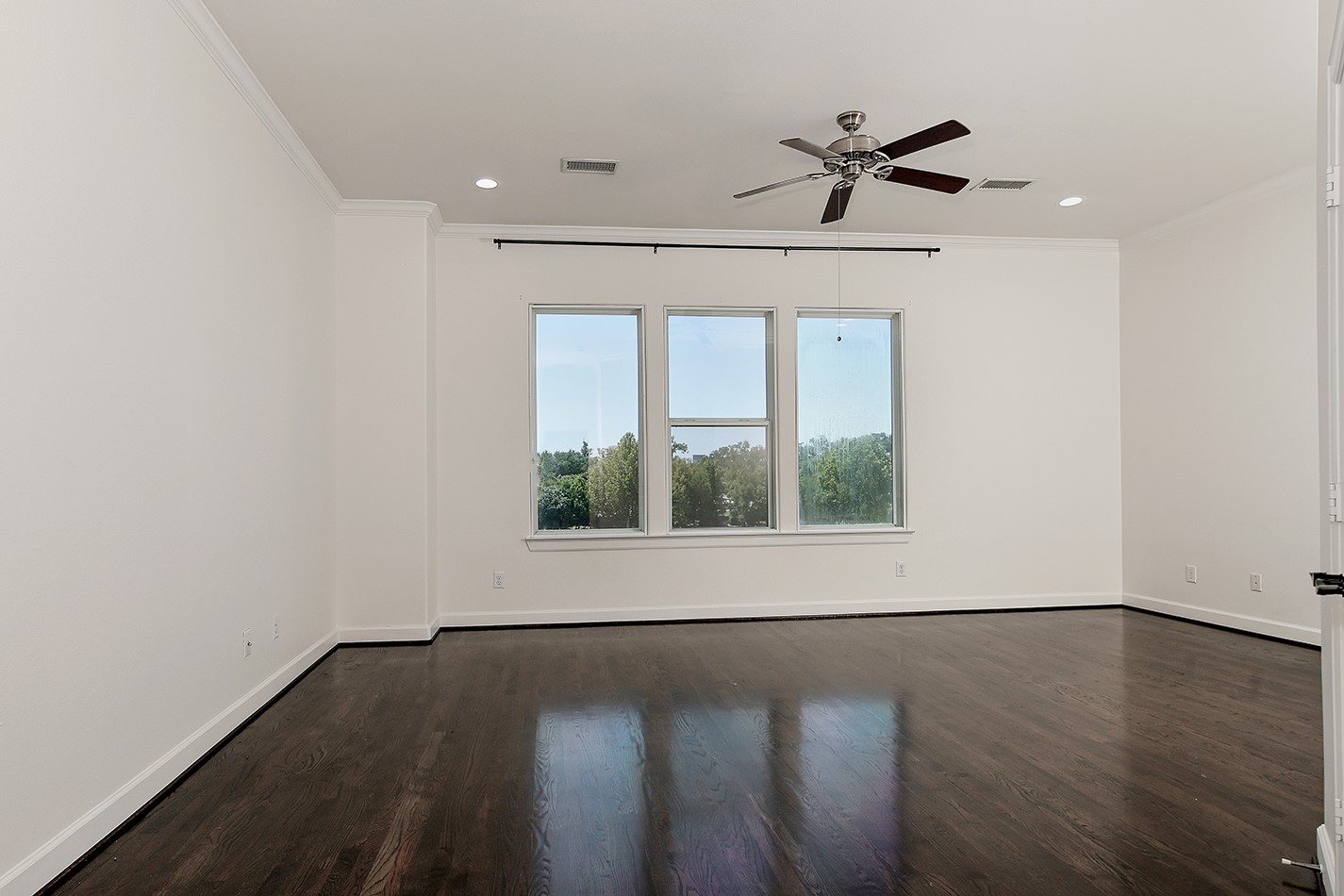 5233 Cornish Street, Unit C Houston, TX 77007 - Photo 20 of 28 an empty room with wooden floor fan and windows