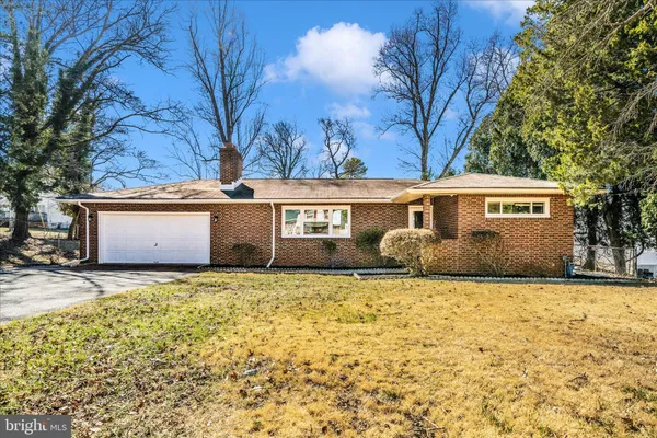 a front view of house with yard and trees in the background