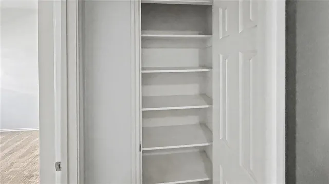 a view of walk in closet with empty racks
