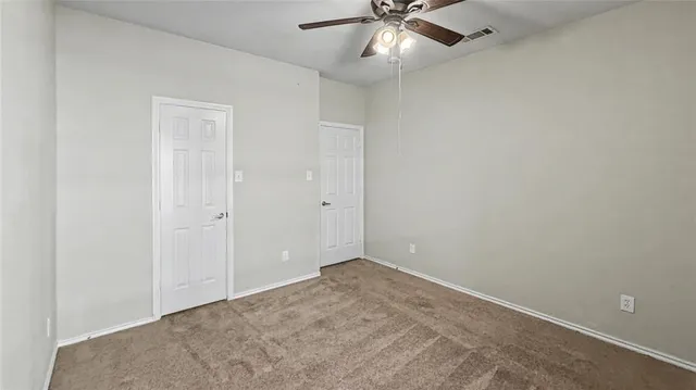 an empty room with a chandelier fan