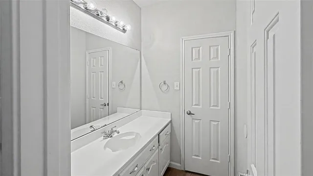 a spacious bathroom with a granite countertop sink and a mirror
