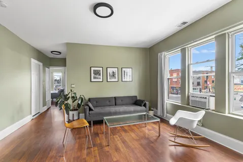 a living room with furniture a wooden floor and a flat screen tv
