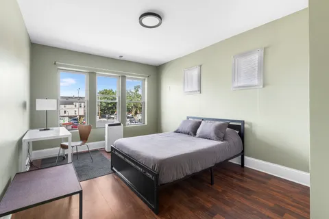 a living room with furniture wooden floor and a large window