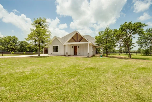 a front view of house with yard and green space