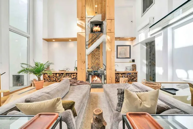 a living room with furniture fireplace and large windows