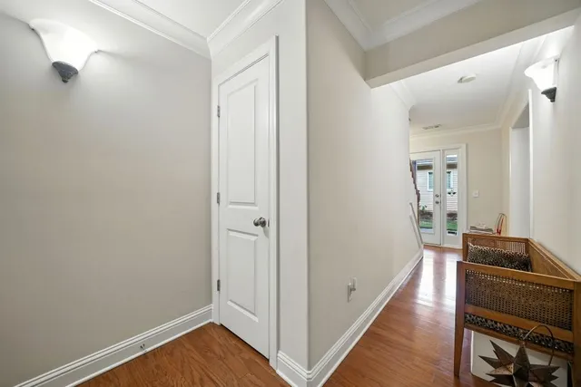 a view of a hallway with wooden floor and cabinet