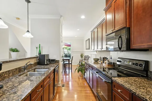 a kitchen with stainless steel appliances granite countertop a sink stove and cabinets