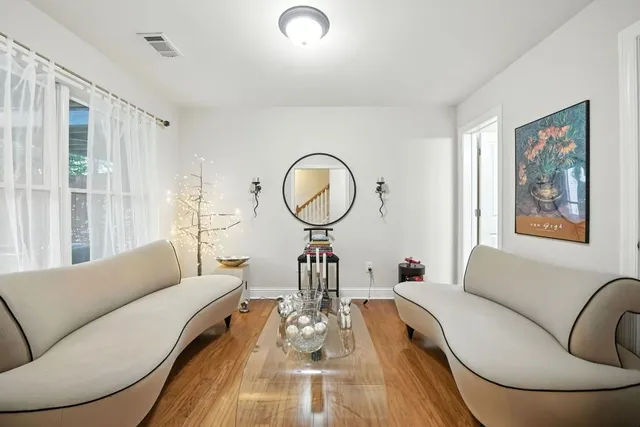 a living room with furniture a mirror and a large window