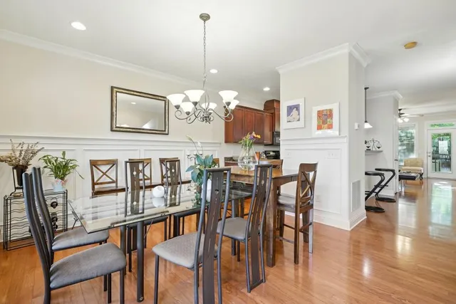 a view of a dining room and livingroom with furniture wooden floor a chandelier