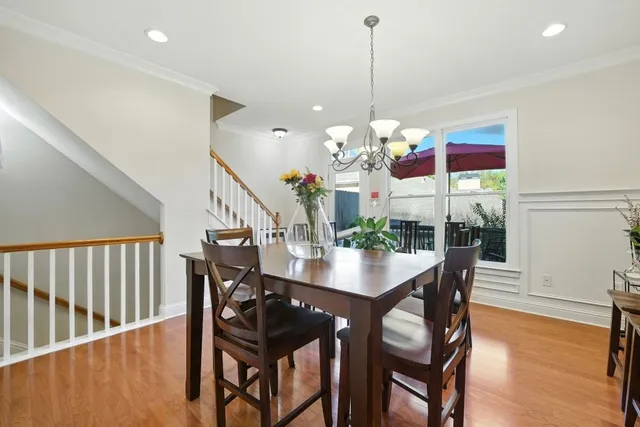 a dining room with furniture a chandelier and wooden floor