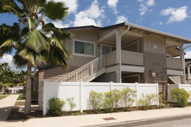 a view of a white house with a yard and potted plants