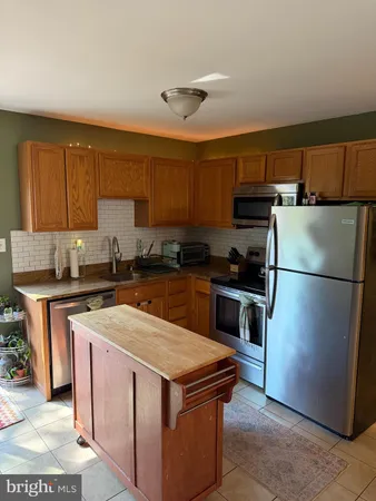 a kitchen with a appliances a sink and a refrigerator