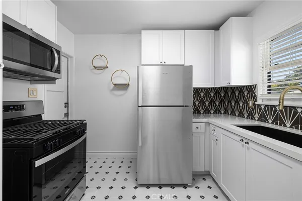 a kitchen with stainless steel appliances granite countertop a refrigerator sink and stove