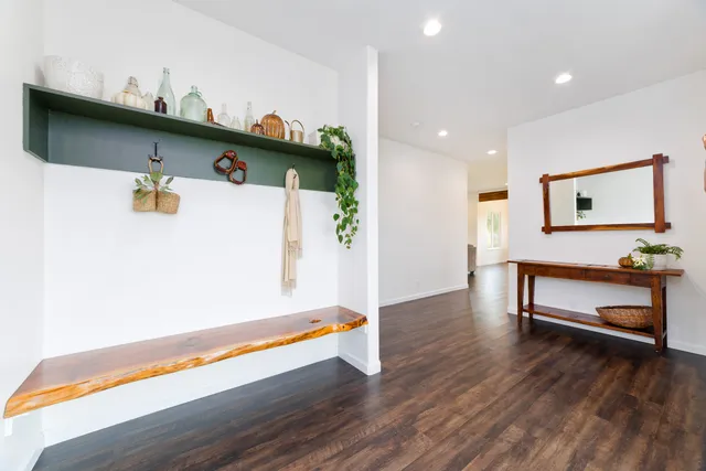 a kitchen with stainless steel appliances granite countertop a table chairs wooden floors a sink and a refrigerator