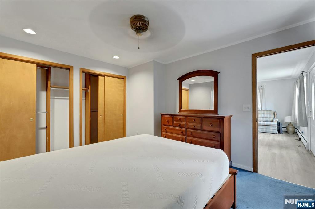 17 Butler Place Wanaque, NJ 07420 - Photo 22 of 28 a bedroom with a large bed and a chandelier