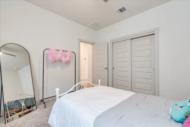 a bedroom with a bed a window and dresser