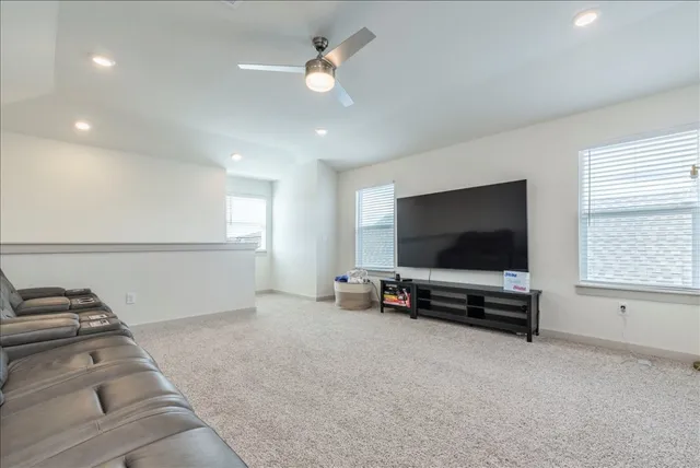 a living room with furniture and a ceiling fan