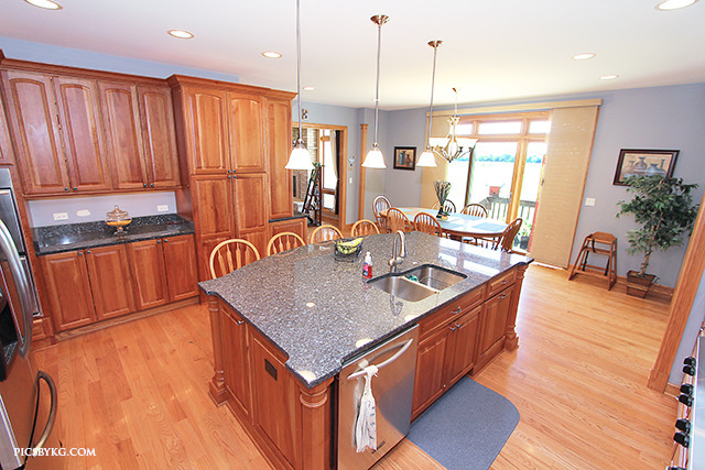 8001 East Tryon Grove Road Richmond, IL 60071 - Photo 7 of 24 a kitchen with stainless steel appliances granite countertop a sink a stove and a wooden floors