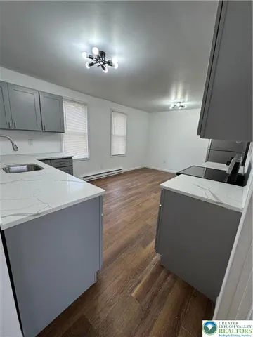 a kitchen with granite countertop a sink a stove and cabinets