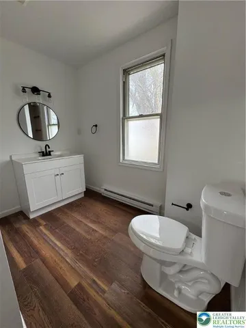 a bathroom with a toilet sink and mirror