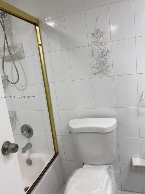 5401 Collins Avenue, Unit 833 Miami Beach, FL 33140 - Photo 9 of 25 a white toilet sitting next to a bathroom sink and a shower