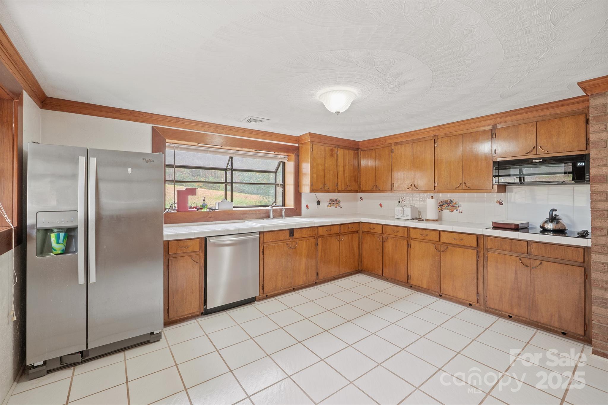 5260 Rifle Range Road Conover, NC 28613 - Photo 14 of 27 a kitchen with granite countertop a refrigerator and white cabinets