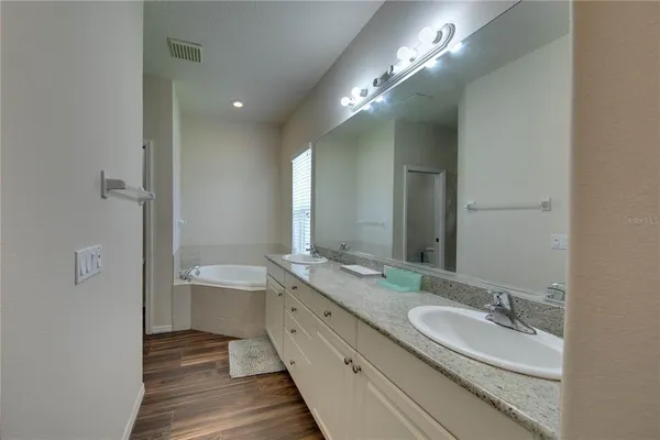 a spacious bathroom with a double vanity sink and a mirror