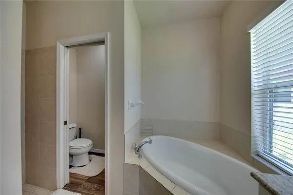 a bath room with a toilet and a bath tub