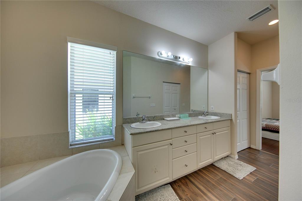 5291 Echo Lane Sarasota, FL 34233 - Photo 19 of 32 a bathroom with a granite countertop double vanity sink a mirror and a bathtub