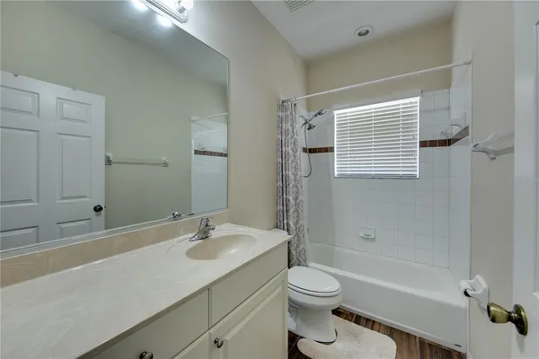 a bathroom with a sink a toilet a mirror and shower
