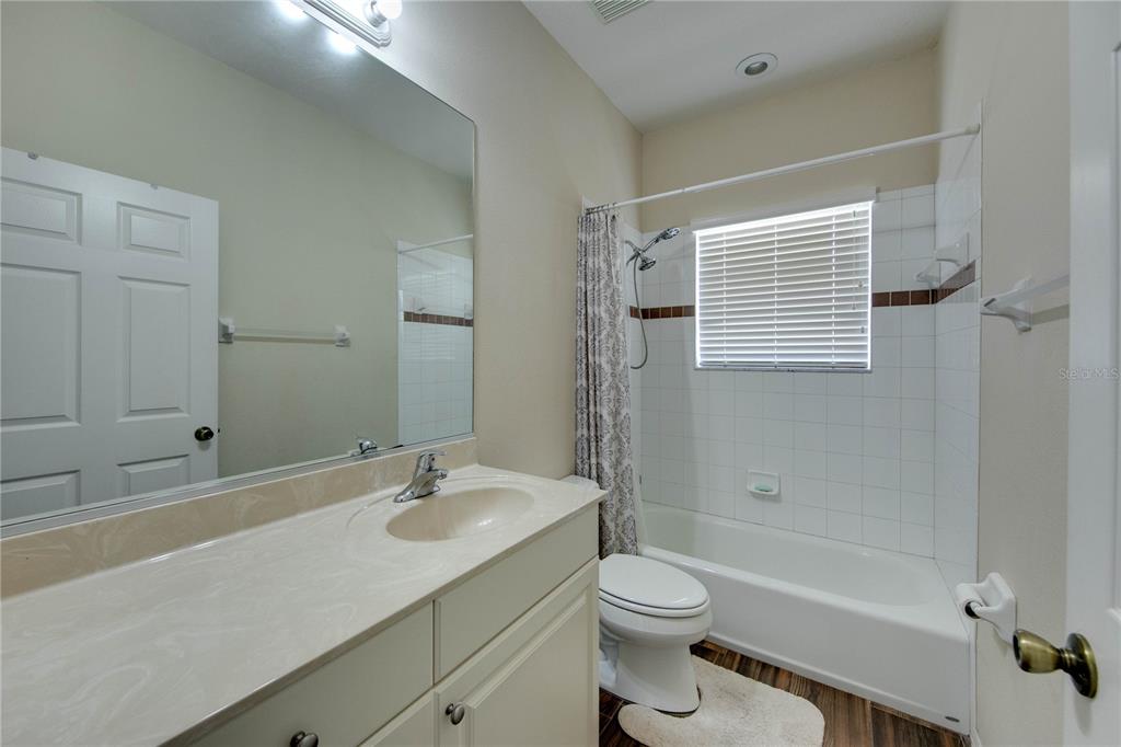 5291 Echo Lane Sarasota, FL 34233 - Photo 2 of 32 a bathroom with a sink a toilet a mirror and shower