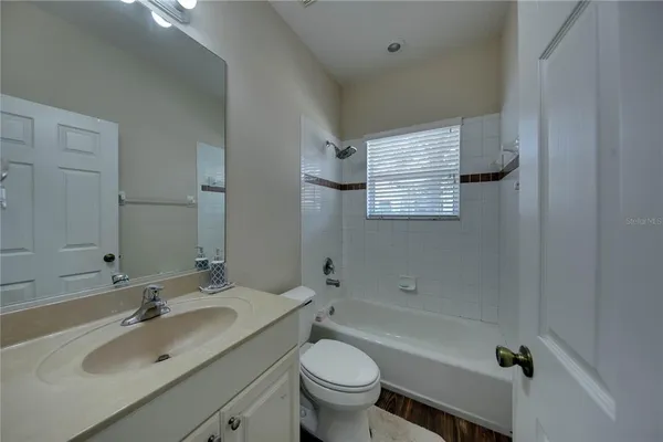 a bathroom with a granite countertop toilet a sink and a bathtub