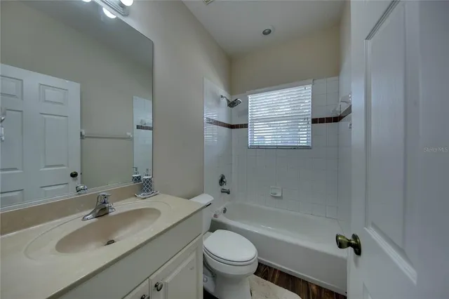 a bathroom with a granite countertop toilet a sink and a bathtub