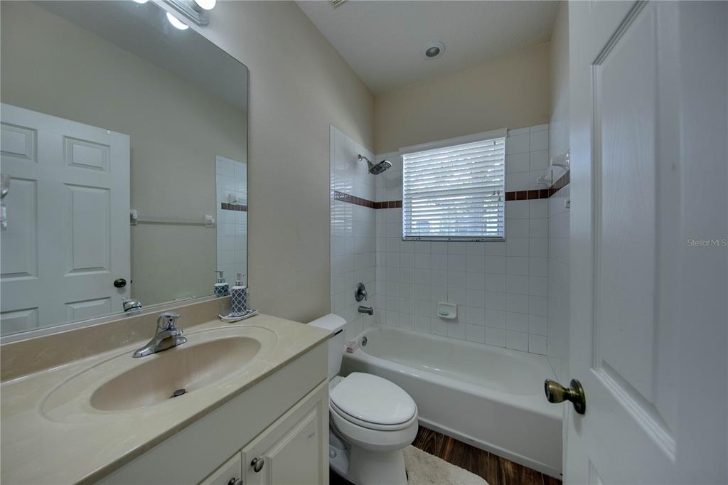 5291 Echo Lane Sarasota, FL 34233 - Photo 24 of 32 a bathroom with a granite countertop toilet a sink and a bathtub
