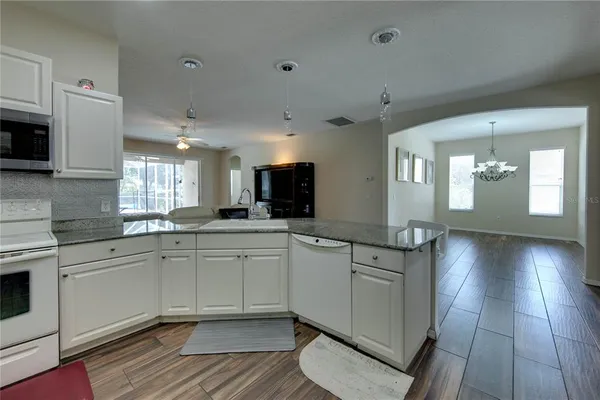 a kitchen with stainless steel appliances granite countertop a sink and cabinets