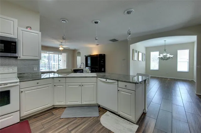 a kitchen with stainless steel appliances granite countertop a sink and cabinets
