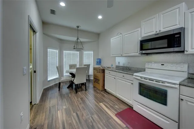 a kitchen with a sink a microwave and cabinets