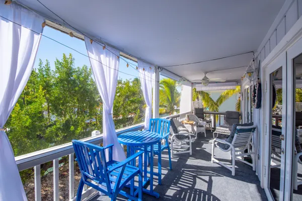 a view of a patio with chairs and floor to ceiling window