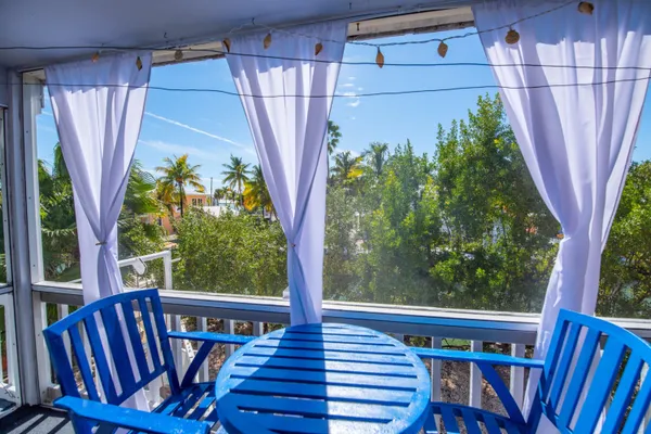 a view of a balcony with wooden floor stairs and outdoor seating