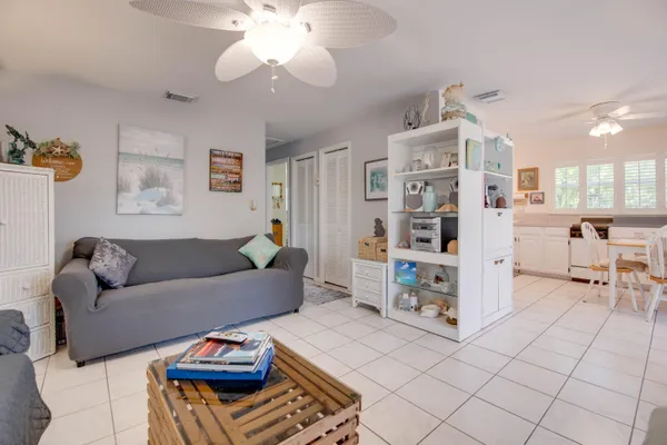 a living room with furniture and a dining table with kitchen view