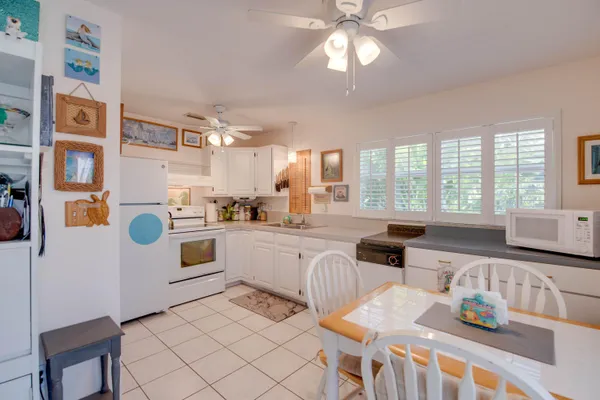 a kitchen with stainless steel appliances granite countertop a stove a sink a dining table and chairs